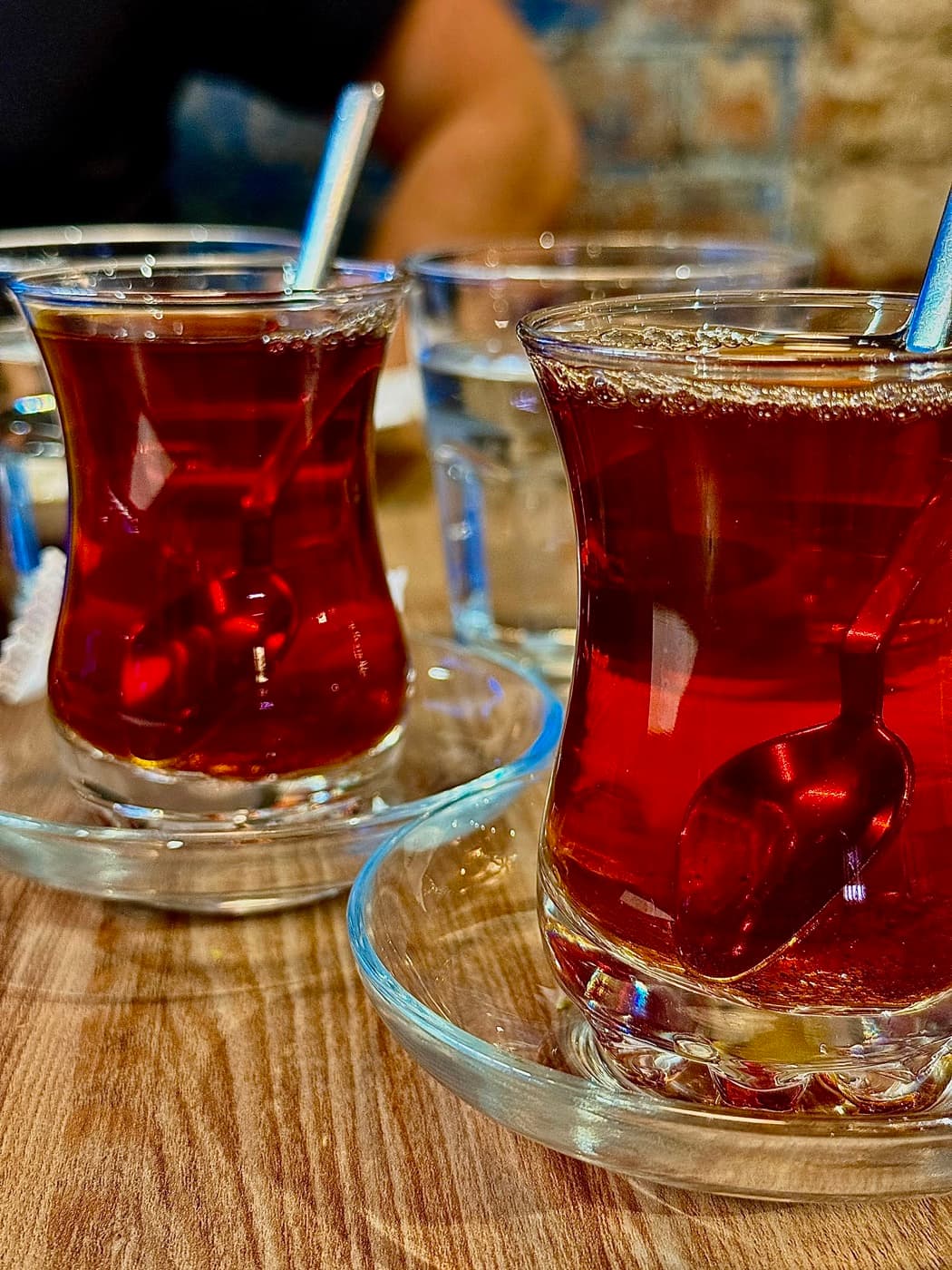 Two glasses of Turkish tea in traditional tulip glasses on saucers at Antep Kitchen Oxford