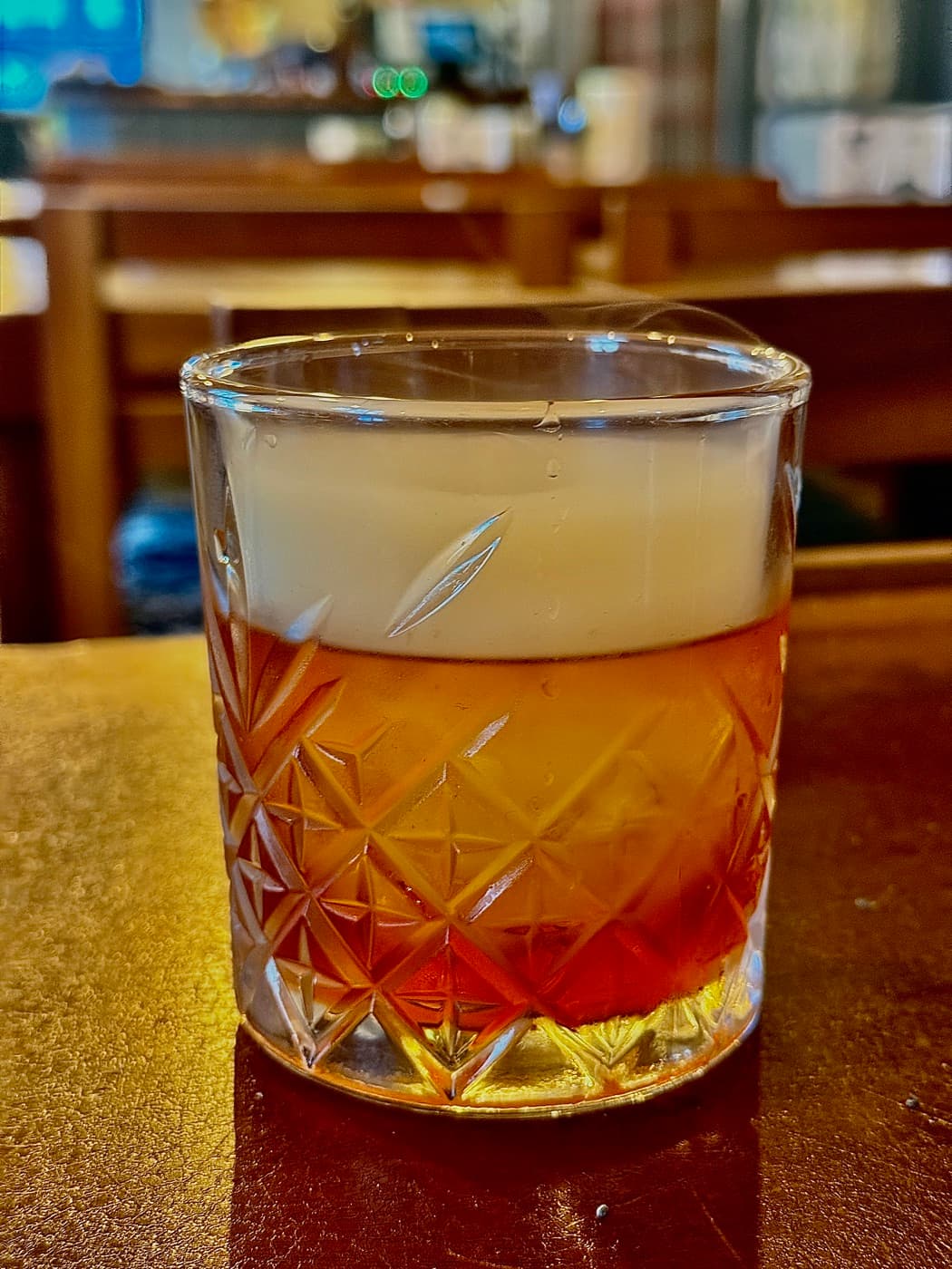 The TCT Smoked Old Fashioned at The Coconut Tree Oxford, served in a cut-glass tumbler with a layer of smoke trapped above the drink